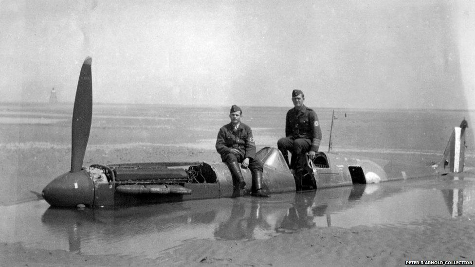 Two German soldiers sitting on the fuselage of Spitfire P9374