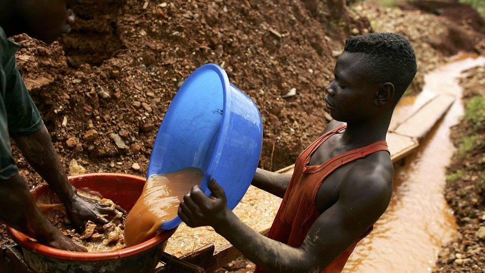 Men sift through dirt and mud while looking for gold 28 March 2006 at an abandoned industrial mine in Mongbwalu, Congo.