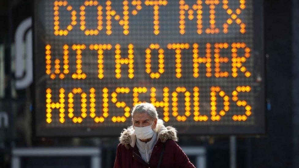 Woman in front of coronavirus sign