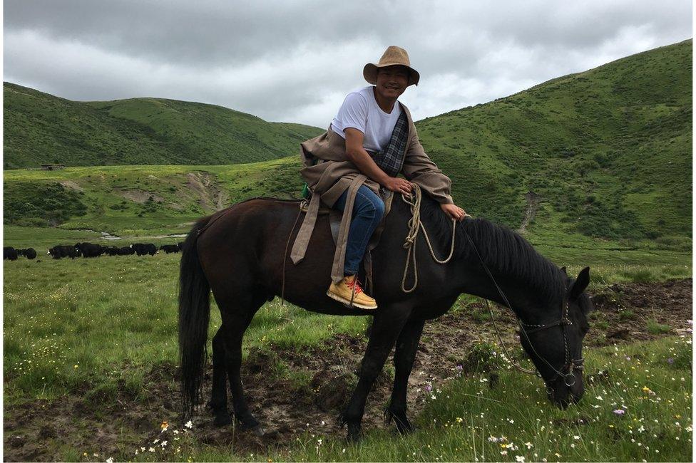 Tshe Bdag Skyabs on his horse amid grass fields