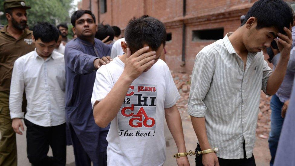 A Pakistani Federal Investigation Agency (FIA) official (3rd L) and a policeman escort to a court handcuffed Chinese nationals accused of allegedly luring young Pakistani girls into fake marriages then forcing them into prostitution in China, on May 11, 2019, in Lahore.