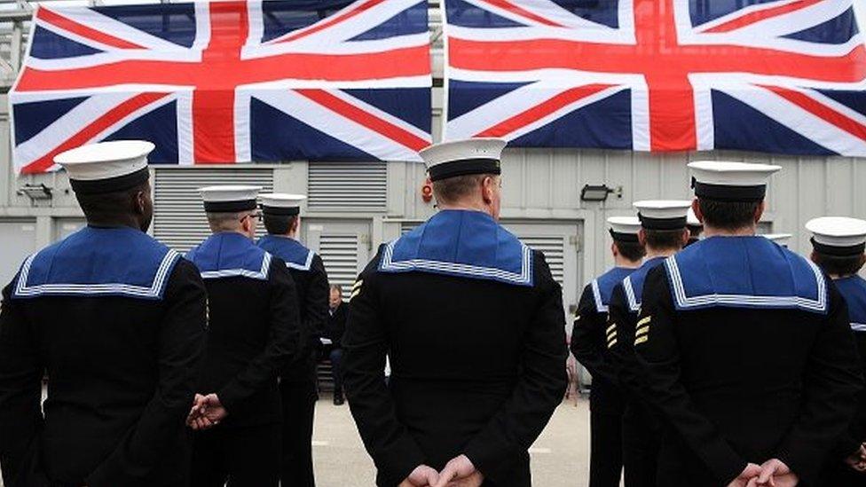 Submariners stand to attention during a ceremony to officially make 'Artful' a commissioned warship of the Royal Navy