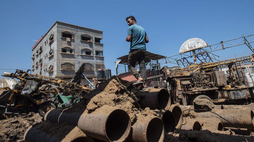 Palestinian man looks at damage following Israeli air strike on workshop in Gaza City on July 2, 2016