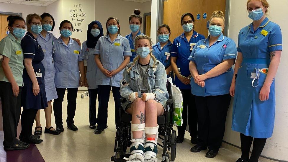 Sadie Kemp in a wheelchair surrounded by hospital staff