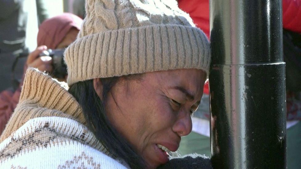 A migrant woman cries