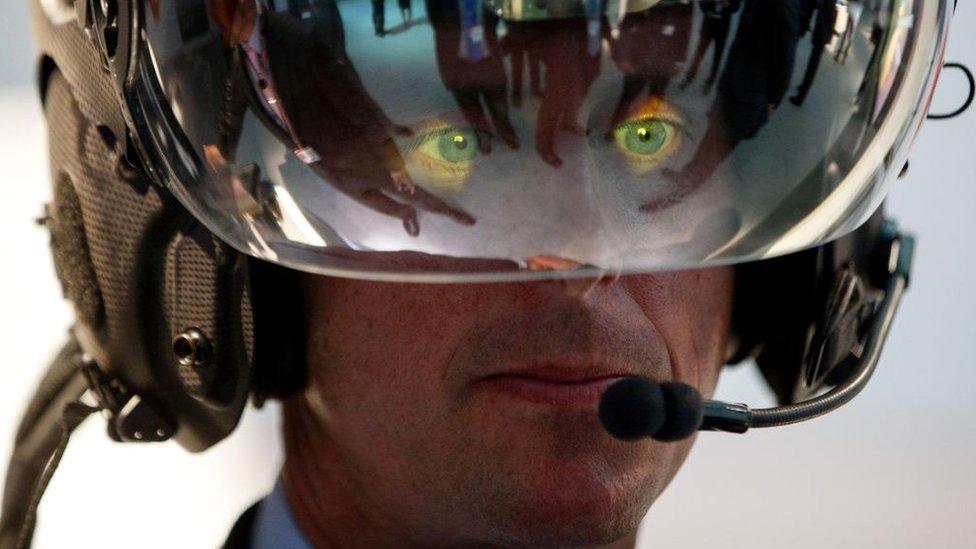 A visitor tries on a Striker II helmet mounted display at the BAE Systems showroom