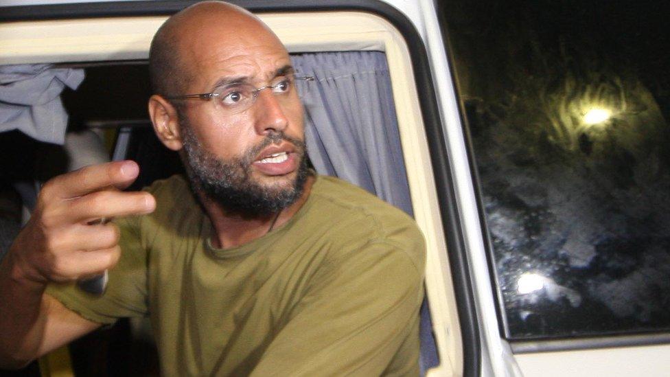 Saif al-Islam Gaddafi appears in front of supporters and journalists at his father's residential complex in the Libyan capital Tripoli in the early hours of 23 August 2011