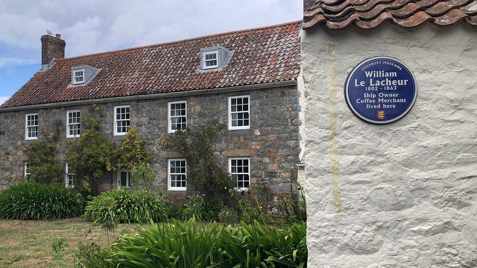 Blue Plaque on a wall by a house