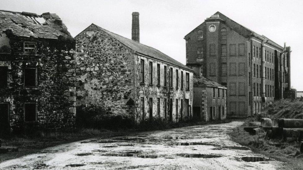 Another angle of Balnamore Mill, showing potholes in road outside the building