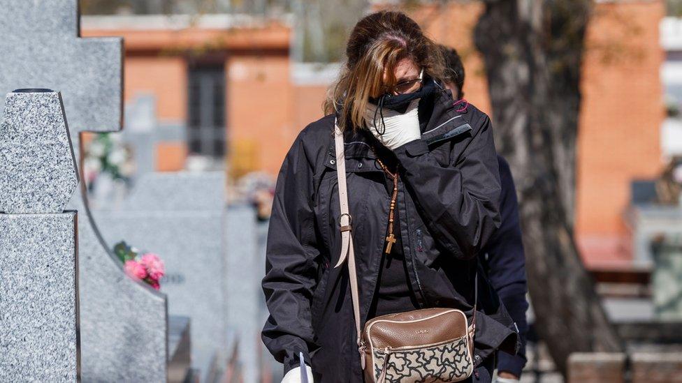 A woman arrives for the burial of a COVID-19 coronavirus victim at the Fuencarral cemetery in Madrid