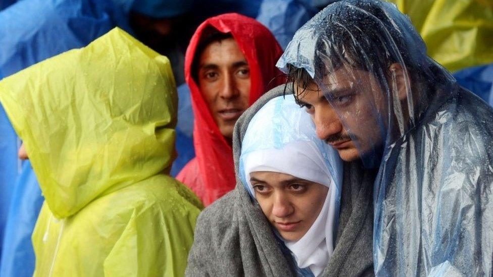 Migrants wait in the rain as they wait to enter Slovenia, at the Croatian-Slovenian border in Trnovec, on 19 October.