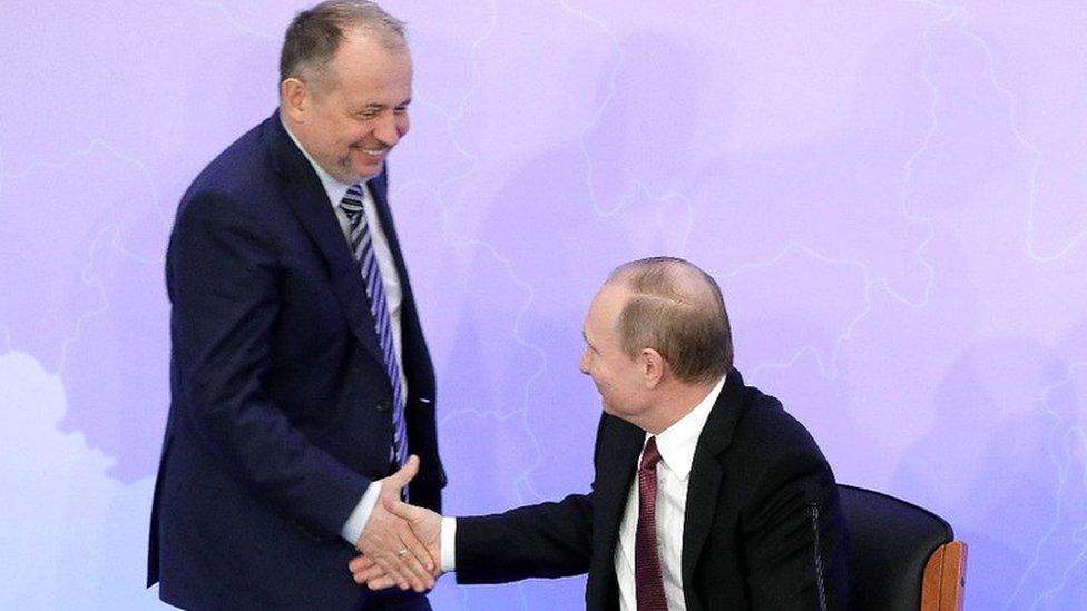 Vladimir Lisin (L) shaking hands with Russia's President Vladimir Putin (R)