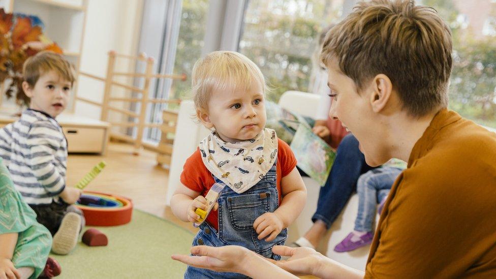 Pre-school teacher playing with little boy - stock photo