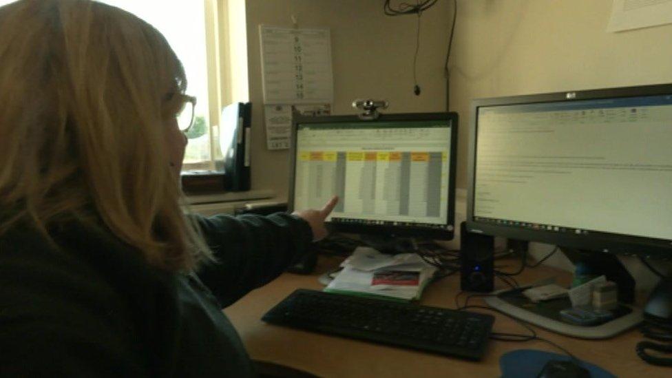 Grace Muir pointing at a computer monitor