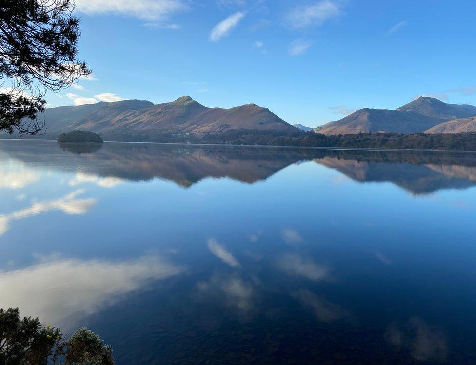 Hills reflected in still water