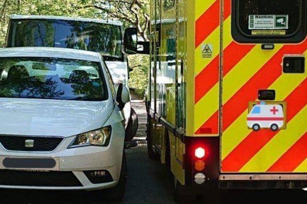 Ambulance squeezes by car