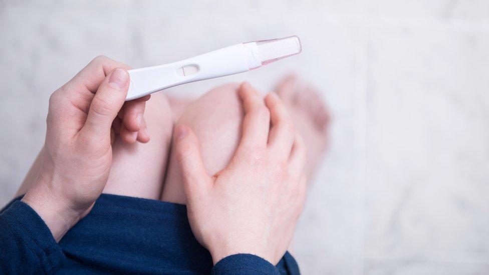 A woman holds a pregnancy test