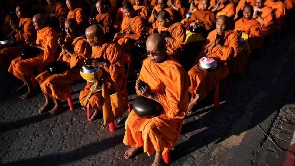 Buddhist monks gather for a mass prayer one week after a lone soldier shot and killed 29 people in Thailand