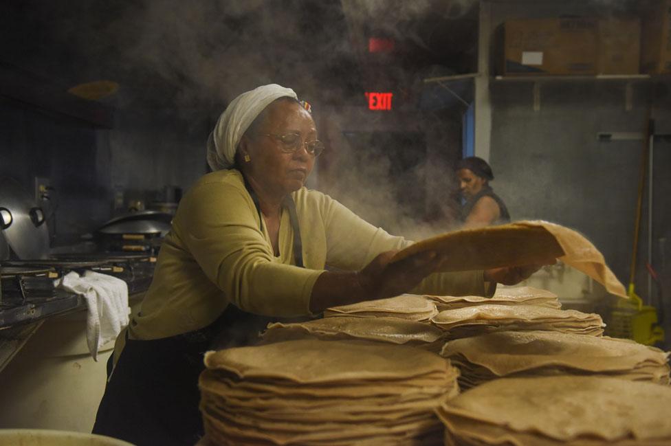 Zenebech Dessu prepares injera, an East African sourdough-risen flatbread at her Zenebech Restaurant in Shaw