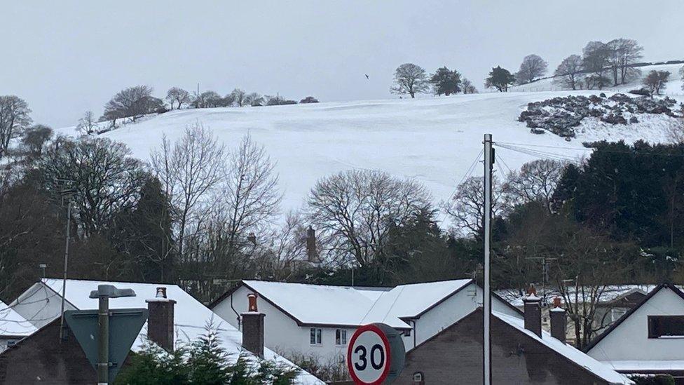 Eira ym mhentref Llanferres ar yr A494 rhwng Rhuthun a'r Wyddgrug