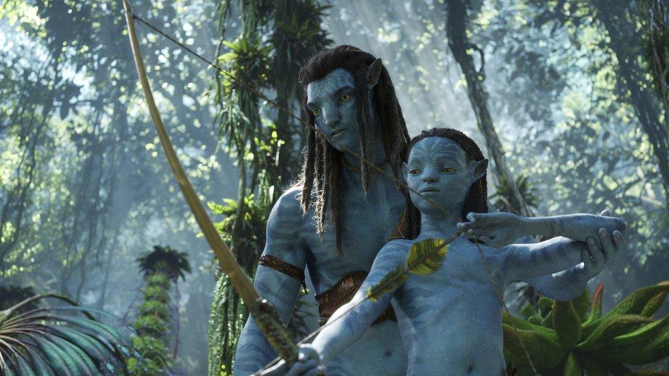 A still from Avatar: Way of the Water showing (left to right) Jake Sully and Neteyam