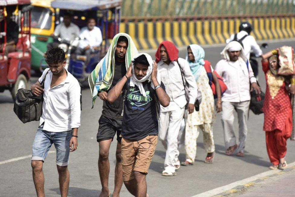 People cover themselves to beat the heat on a summer day, as temperatures in the capital reach 45 degree Celsius, on May 31, 2019 in Noida, India.