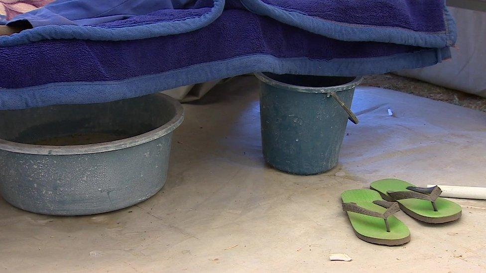 Two buckets next to a patient's bed