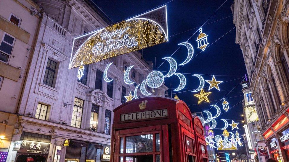 Red telephone box in the foreground of Ramadan lights in Piccadilly