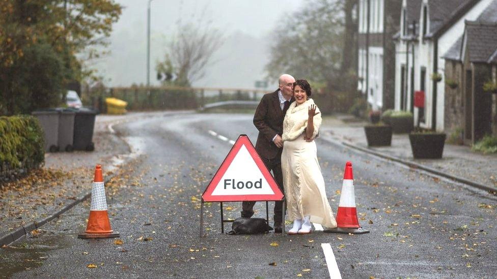 Robert Connelly and Annalisa Falanga wedding pic behind flood sign