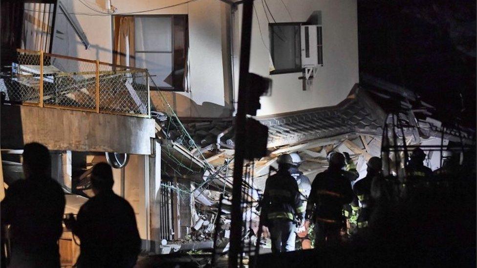 Firefighters search for trapped residents at a collapsed house in Mashiki, near Kumamoto city, southern Japan, after the earthquake early Friday, April 15, 2016.