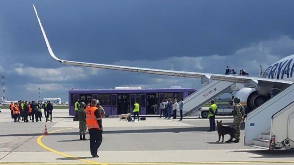 Airport personnel and security forces are seen on the tarmac in front of a Ryanair flight which was forced to land in Minsk, Belarus. Photo: 23 May 2021