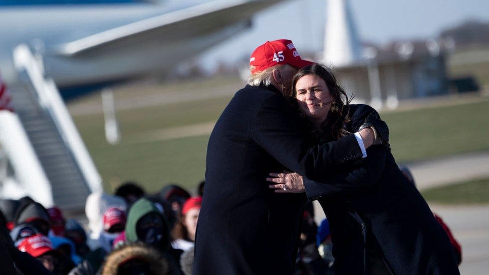 Donald Trump hugs his former press secretary Sarah Huckabee Sanders during a Make America Great Again rally at Dubuque Regional Airport