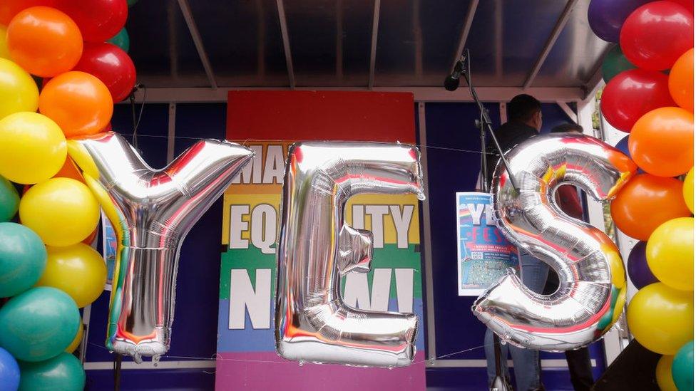 The stage is set for a rally in support of same sex marriage with balloon letters reading YES and rainbow balloons