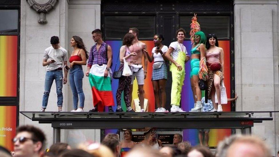 Revellers standing on a bus stop roof