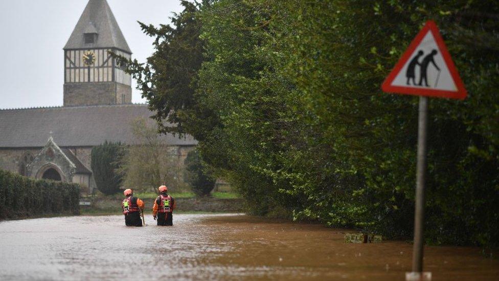 Hereford Fire and Rescue personnel check the depth of flood water as they go along a flooded road in the village of Hampton Bishop in Herefordshire, western England on February 20, 2020