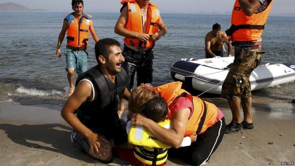 Iranian migrant cries next to his son and wife moments after arriving on a Kos beach in a small, exhausted group that paddled a dinghy from Turkey 15/08/2015