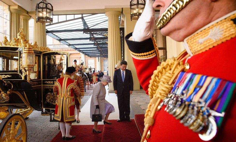 Queen Elizabeth II and China's President Xi Jinping (R) arrive at Buckingham Palace