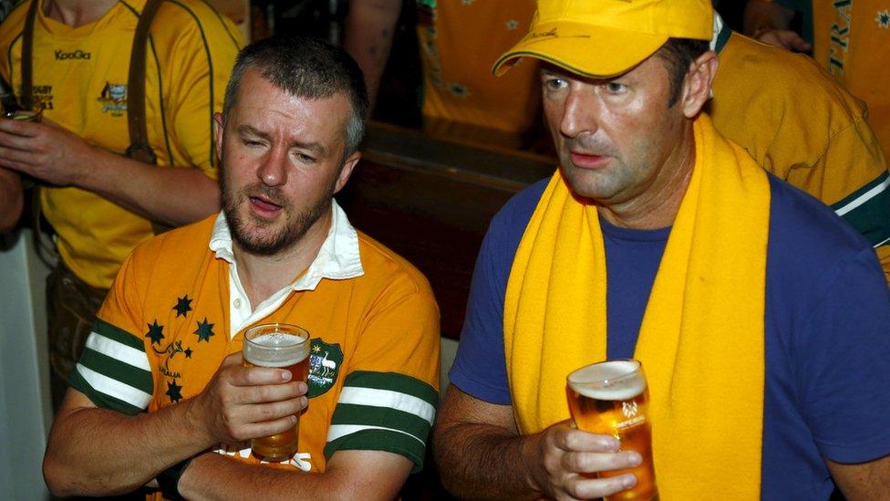 Fans of Australia"s Wallabies Rugby team react as they watch a live telecast of their team"s loss to New Zealand"s All Blacks during the Rugby World Cup final at a pub in Sydney