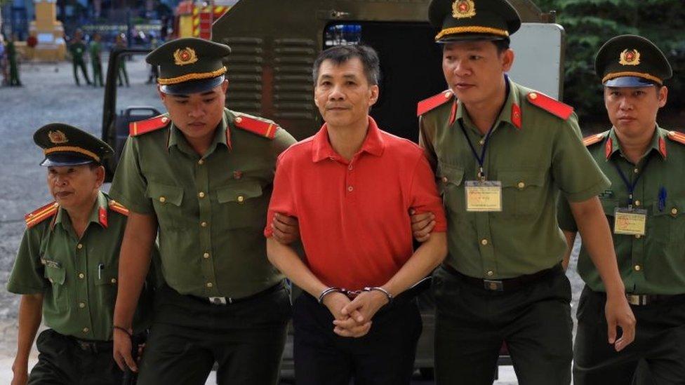 Michael Phuong Minh Nguyen (centre) is escorted by Vietnamese police to a court in Ho Chi Minh. Photo: 24 June 2019