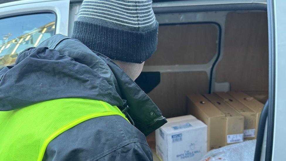 Police officer dressed as delivery driver alongside decoy van