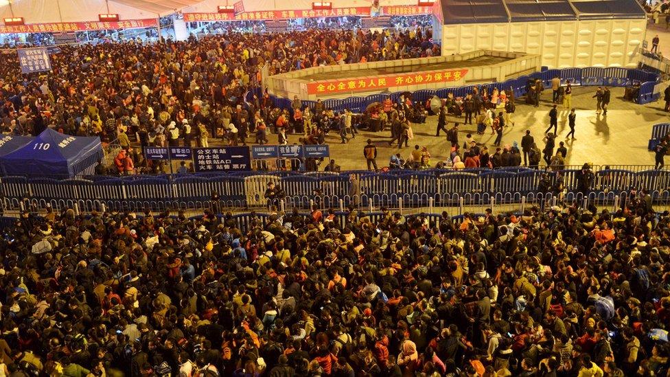 Passengers wait to enter a railway station in Guangzhou