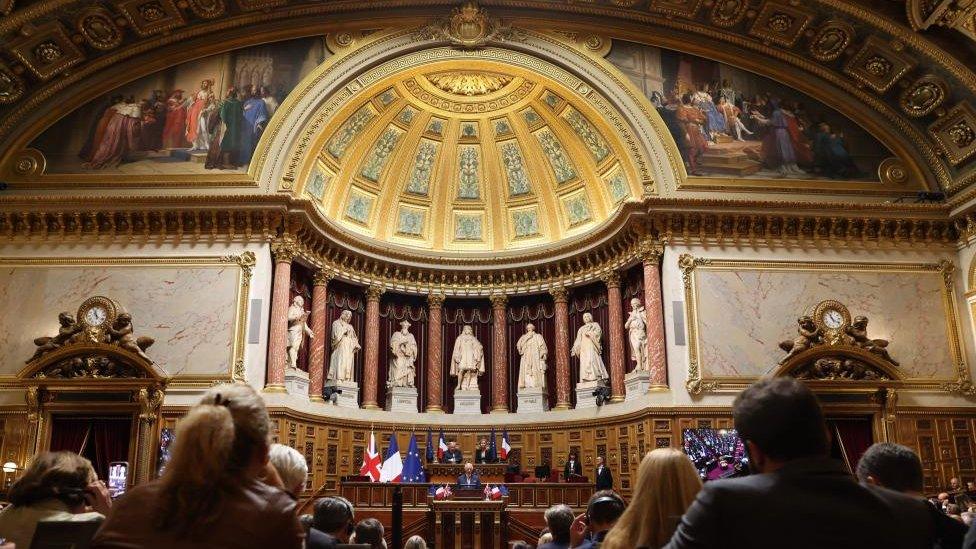 A wide-angled photograph of King Charles giving his speech to the French Senate building