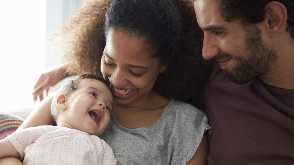 Stock image of a couple holding a baby