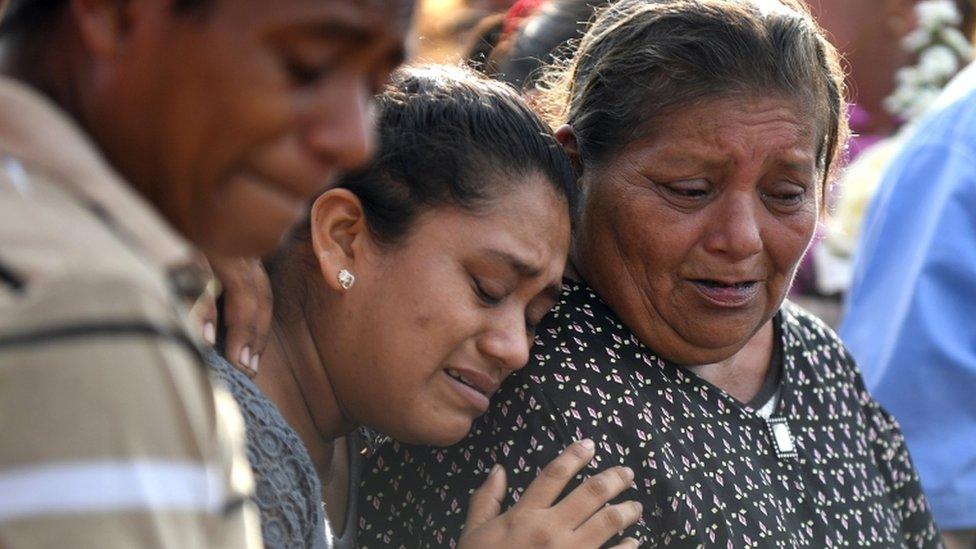 Mourners crying at a funeral