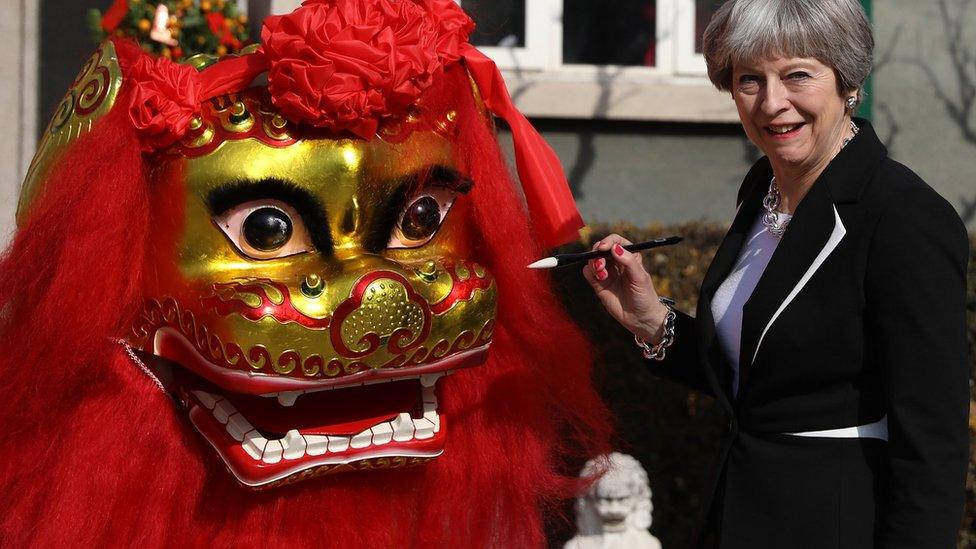 Theresa May "dots the eyes" of a dragon outside the British Embassy on 1 February 2018 in Beijing