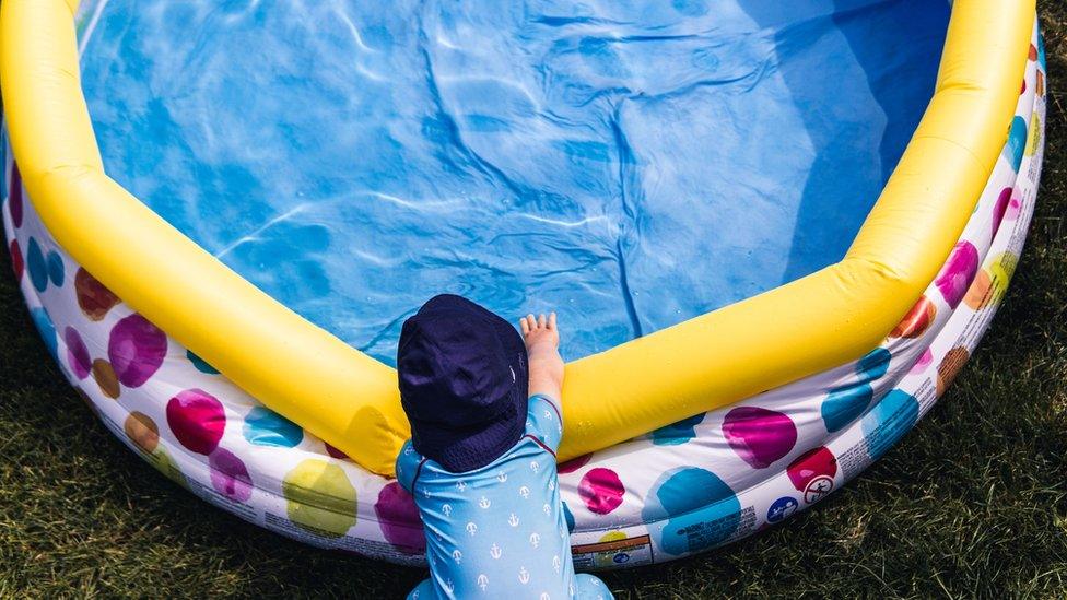 Child and paddling pool stock image