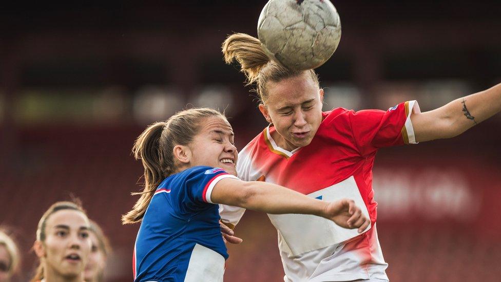 Two-girls-heading-the-ball.