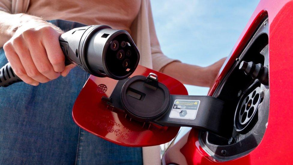 Woman charging electric car