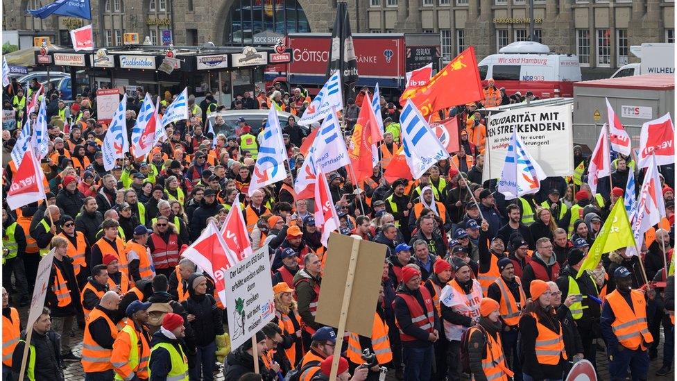 Workers on strke wave signs in Hamburg