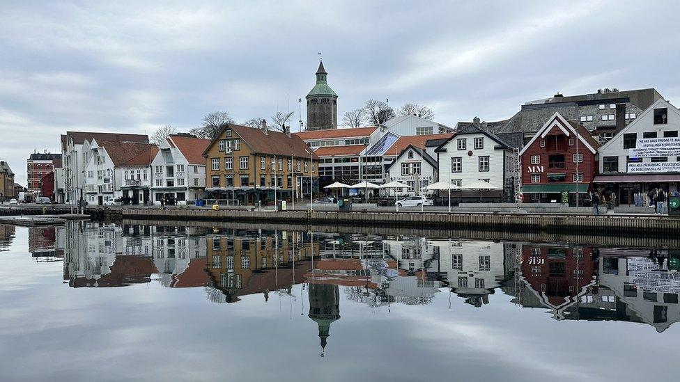 A line of buildings reflected in water